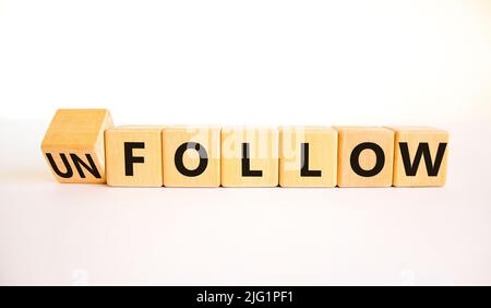 Follow or unfollow symbol. Turned wooden cubes and changed concept words Follow to Unfollow. Beautiful white table white background. Business and foll Stock Photo