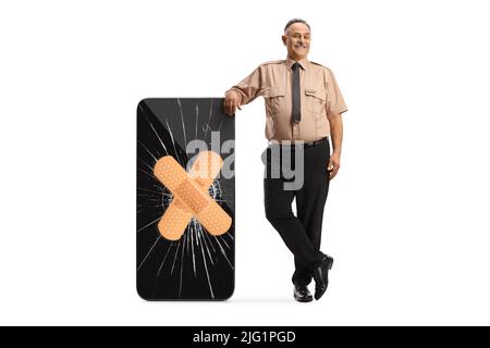 Security guard leaning on a broken smartphone fixed with adhesive bandage isolated on white background Stock Photo