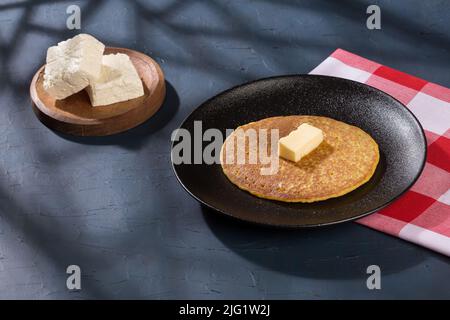 Typical food in Colombia - tasty arepa de choclo with butter and cheese. Stock Photo