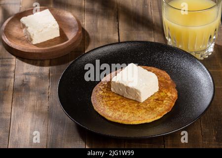 Typical food in Colombia - tasty arepa de choclo with butter and cheese. Stock Photo