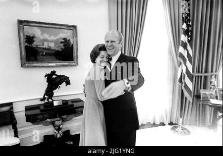 President and Mrs. Ford hug each other in the Oval Office. December 6, 1974. Stock Photo