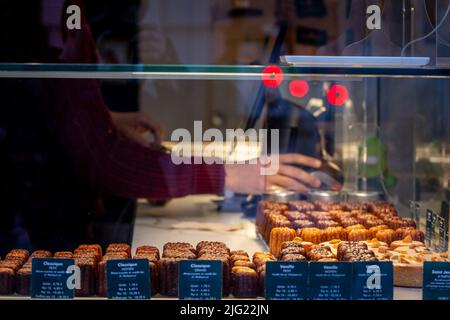 Picture of a shop, a bakery, selling Caneles Bordeaux, in the city center of Bordeaux, France. A canelé is a small French pastry flavored with rum and Stock Photo