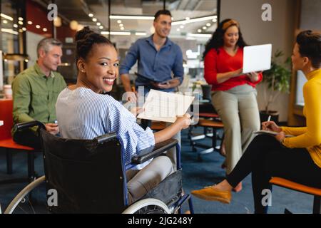 Portrait of smiling african american businesswoman with disability in meeting at office Stock Photo