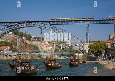 Dom Luis I bridge over the Douro river with moored traditional port wine boats, Porto, Portugal, Europe. Stock Photo