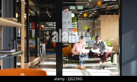 Multiracial creative businessman and businesswoman discussing business strategy in office Stock Photo