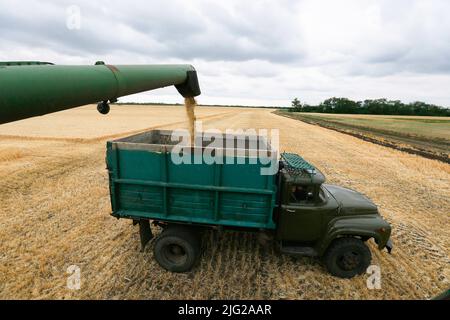 Odessa, Ukraine. 23rd June, 2022. A combine unloads barley grain into a truck in a field in Odesa region the South of Ukraine. As Russian invasion in Ukraine continues, more than 20 million tones of Ukrainian grain were blocked at the Ukrainian ports, a significant part of which was intended for the UN World Food Programme, reportedly by local media. (Photo by Pavlo Gonchar/SOPA Images/Sipa USA) Credit: Sipa USA/Alamy Live News Stock Photo
