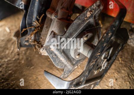 Tiller of a small walk-behind tractor close-up. Manual walk-behind tractor for plowing the soil of the garden Stock Photo