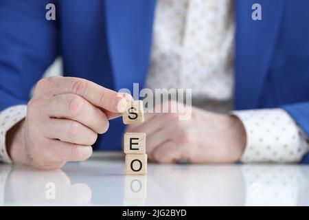 Businessman collecting words seo with wooden cubes Stock Photo