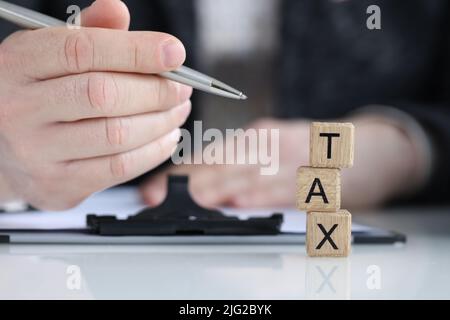 Tax word collected of wooden blocks letters in row Stock Photo
