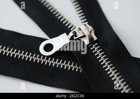 Open and closed metal zippers for clothing on white background Stock Photo