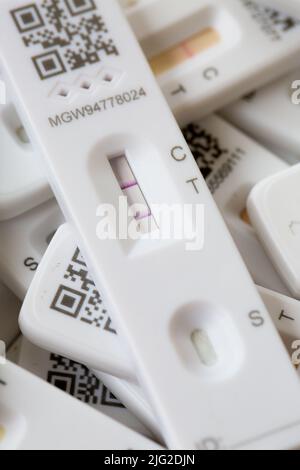 SELBY, UK - JUNE 6, 2022.  A positive result for Coronavirus on a lateral flow home testing kit with other results showing negative. Stock Photo