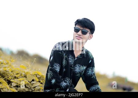 Young Man Wearing Sunglasses Sitting Outdoors · Free Stock Photo