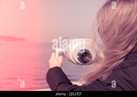 Tourist looking through coin operated binoculars. Binocular telescope on the observation deck for tourism. Sea background. Binoculars watching at horizon at ship deck. Discover new places Travel tourist destination attraction. Copy space for text. Sopot on the pier Stock Photo