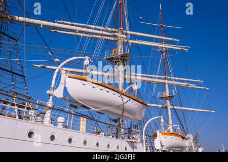 Gdynia Poland May 2022 Flag of Poland waving on flag pole of ship. Polish flag fluttering while sailing boat on sea. Sunny day Stock Photo