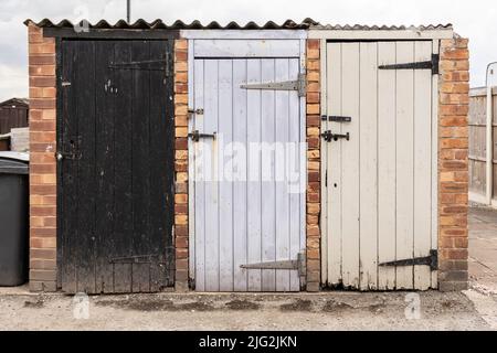 vintage coal bunkers with multicoloured and weathered doors Stock Photo