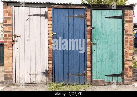 vintage coal bunkers with multicoloured and weathered doors Stock Photo