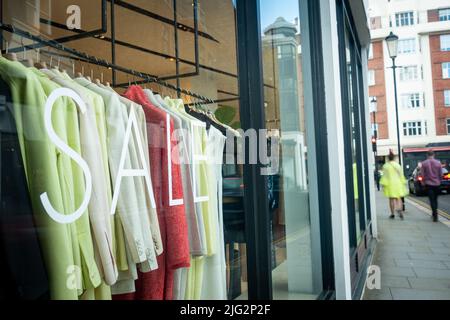 High Street clothes store with ‘Sale’ text in shop window Stock Photo