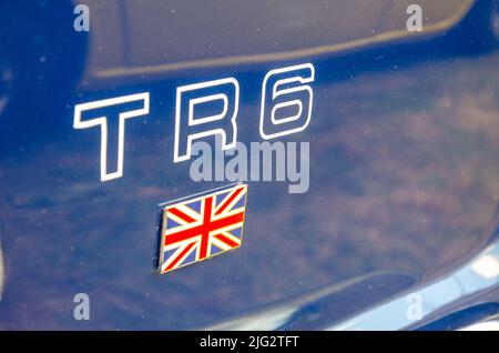 Side view of a vintage Triumph TR6 sports car, in brilliant red, on ...