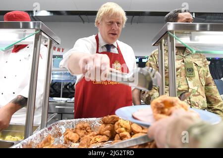 File photo dated 21/12/2019 of Prime Minister Boris Johnson serving Christmas lunch to British troops stationed in Estonia during a one-day visit to the Baltic country. Boris Johnson will publicly announce his resignation later today, likely before lunchtime, the BBC is reporting. Issue date: Thursday July 7, 2022. Stock Photo