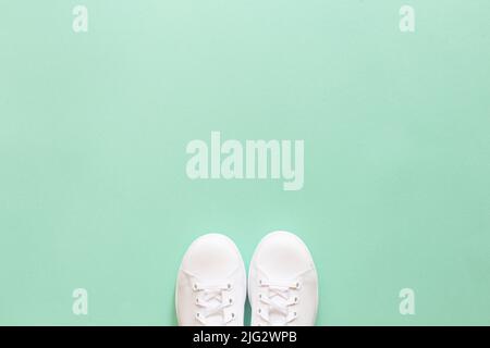 All white sneakers on mint green background. Top view,flat lay Stock Photo