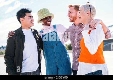 Two women and two men at park talking laughing and enjoying their time. friends hanging out and talking outdoors in summer park Stock Photo