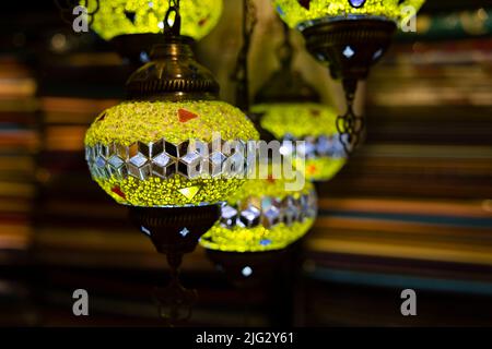 Traditional handmade multicolor Turkish, Moroccan, Arabian lamps hanging with nice blurred background. Mosaic style and colored glass lantern. Stock Photo