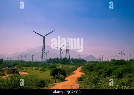 Beautiful view of Windmills or Wind Turbines farm in Nagercoil, South India. With a colorful sky and mountains as a background. Stock Photo