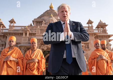 File photo dated 21/04/22 of shoeless Prime Minister Boris Johnson walking with sadhus, Hindu holymen, as he visits the Swaminarayan Akshardham temple in Gandhinagar, Ahmedabad, as part of his two day trip to India. Boris Johnson will publicly announce his resignation later today, likely before lunchtime, the BBC is reporting. Issue date: Thursday July 7, 2022. Stock Photo