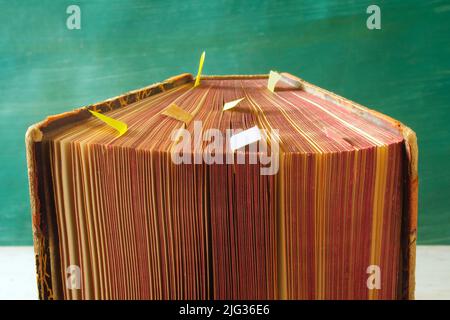 Open book, vintage hardback on teal background, selective focus,close up. Education, reading, learning concept. Stock Photo