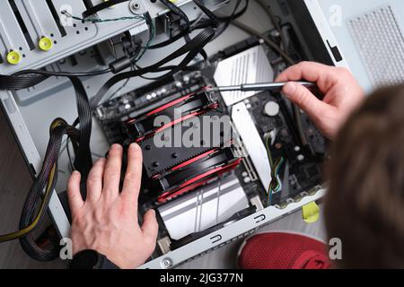 Repairman works with screwdriver and repairs computer equipment Stock Photo