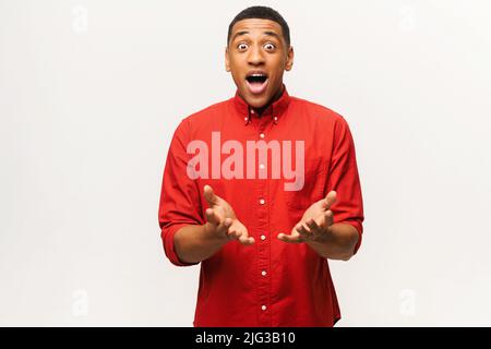 Surprised with amazing sale price multiracial young guy, shock male isolated on white wall. Stunned African-American guy looking at the camera with mouth open Stock Photo