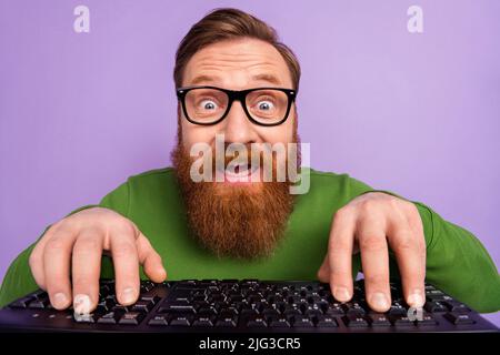 Portrait of young geek nerd in spectacles writing code making new html application isolated on violet color background Stock Photo