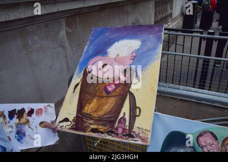 London, UK. 7th July 2022. Political artist Kaya Mar paints what is likely to be his last Boris Johnson painting outside Downing Street as Johnson  announces his resignation. Credit: Vuk Valcic/Alamy Live News Stock Photo