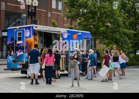 Boston, MA, US-June 11, 2022: People lined up at food truck on a summer day in downtown neighborhood. Stock Photo