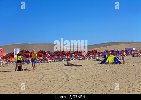 Menschen am Strand bei den Duenen, die Duenen erstrecken sich von Maspalomas bis Playa del Ingles und wurden 1987 zum Naturschutzgebiet erklaert, Masp Stock Photo