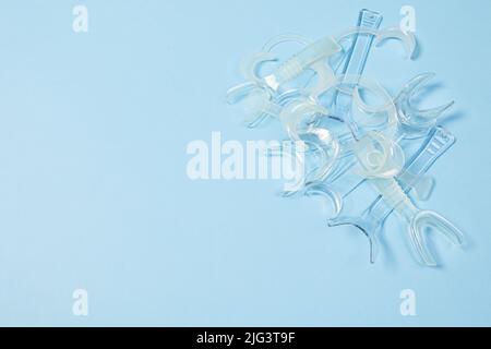 set of several Retractor Dental lip retractor Access to the oral cavity. Wide mouth opening for a dental procedure on a blue background Stock Photo