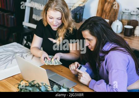 Girls use a credit card to pay in an online store.  Stock Photo