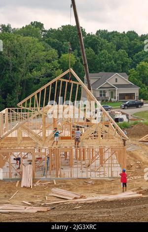 new house construction, framed, men working, crane putting piece into place, home, 2 story building, industry, business, job, Pennsylvania Stock Photo