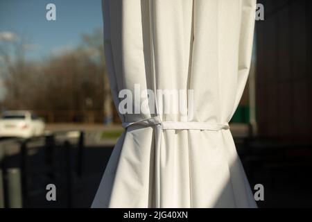 White umbrella on veranda. Sun protection. Stock Photo