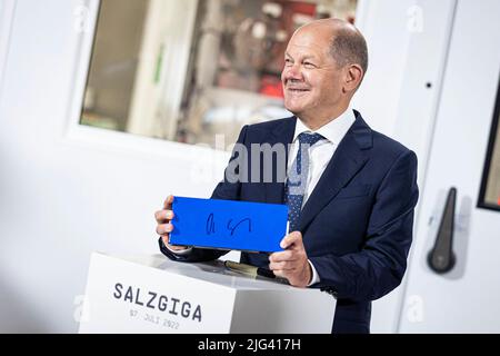 Salzgitter, Germany. 07th July, 2022. German Chancellor Olaf Scholz (SPD) stands at an event to mark the start of construction of Volkswagen's battery cell factory for e-vehicles in Salzgitter with a battery cell he had previously signed. The site of the existing engine plant is to be expanded to include its own cell production. Credit: Moritz Frankenberg/dpa/Alamy Live News Stock Photo