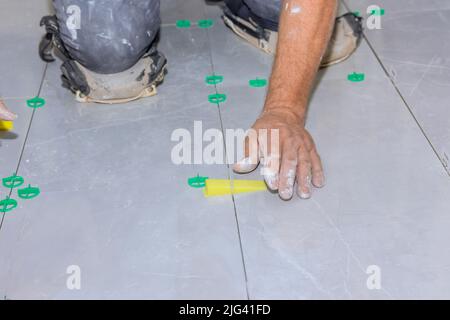 The use of plastic clips and wedges to level tiles in a bathroom construction project Stock Photo