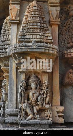 Sculpture of Lord Vishnu in a sitting position on Nageshvara-Chennakeshava temple, Mosale, Hassan, Karnataka, India. Stock Photo