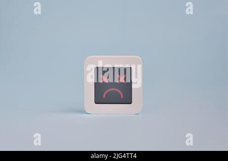 Dead face emotion concept, symbol of dead emoticon on lcd display isolated on colored background, a system crash symbol, Customer Experience Concept Stock Photo