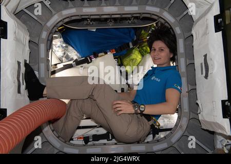 International Space Station Expedition 67 Flight Engineer Samantha Cristoforetti of the ESA, inside the vestibule between the Unity module and the Cygnus space freighter finalizing cargo operations aboard the orbiting spacelab, June 27, 2022 in Earth Orbit. Stock Photo