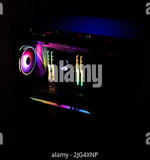 A high end gaming computer is illuminated with rainbow colors. All hardware components are shining in in different colors. Stock Photo