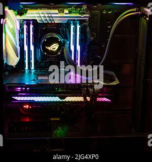 A high end gaming computer is illuminated with rainbow colors. All hardware components are shining in in different colors. Stock Photo