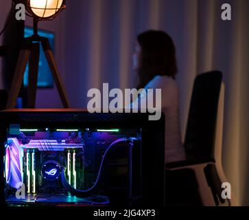 A gamer woman is working on her computer. Stock Photo