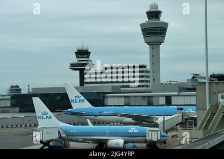 KLM planes at gates in front of  airport control towers at Schiphol Amsterdam airport June 30th 2022 Stock Photo