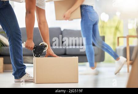 This ones done. Shot of an unrecognizable couple packing boxes for their move at home. Stock Photo