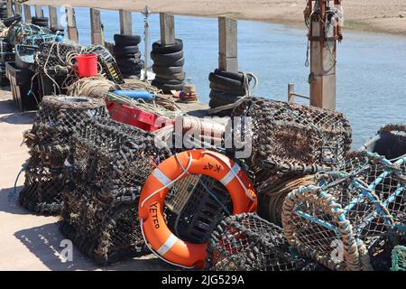 Lobster pots and other various pieces of fishing equipment piled up by the river Axe at Axmouth Stock Photo